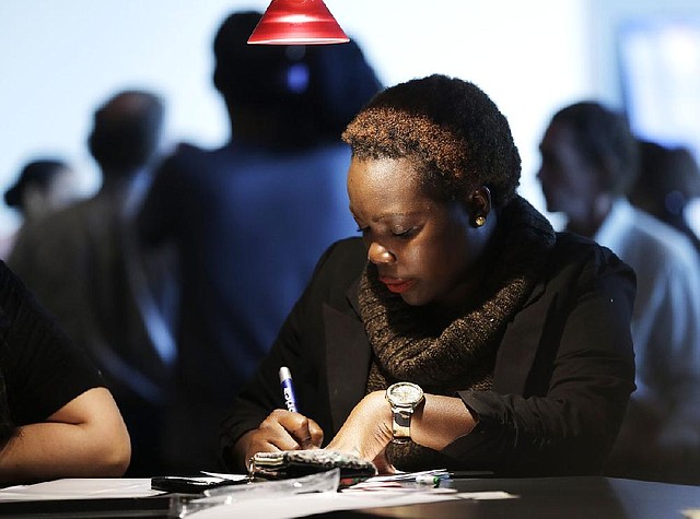 A job seeker completes an application form last month at a job fair in Sunrise, Fla. Last week, unemployment claims decreased by 27,000, the Labor Department said Thursday. 