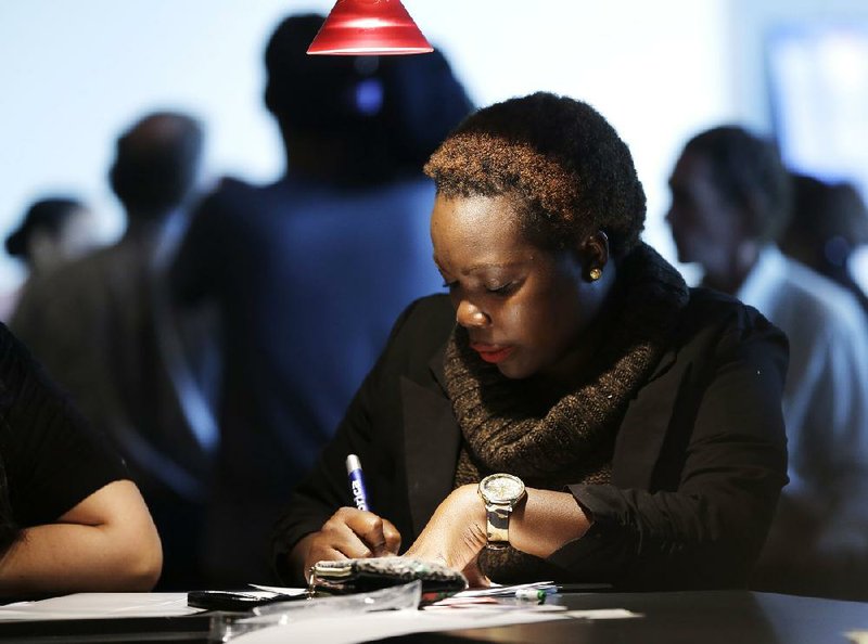 A job seeker completes an application form last month at a job fair in Sunrise, Fla. Last week, unemployment claims decreased by 27,000, the Labor Department said Thursday. 