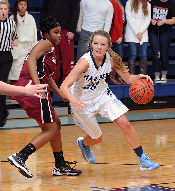 Caylee Wright, right, of Springdale Har-Ber drives around Baiyinnah Taylor of Springdale High during Tuesday’s game at Wildcat Arena. 