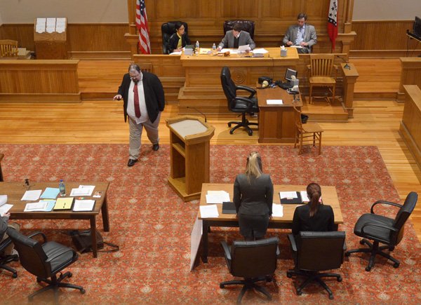 Robert Goins, left, University of Arkansas law student with the school’s law team, walks back to his desk Thursday after speaking with the judges, from left, Sonya Dodson, Michael Dodson and Vince Chaddick during a mock trial in the courtroom at the Old Washington County Courthouse during the the Regional Championship of the annual National Trial Competition. The regional championship brings together 22 teams from law schools in Arkansas, Oklahoma, Kansas and Tennessee. The top two teams will compete in the National Competition in San Antonio on April 3-6. 