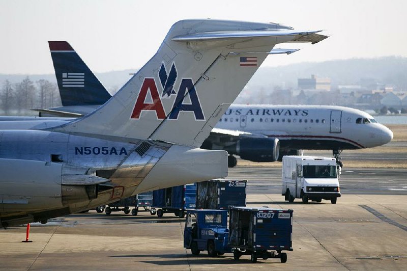 A US Airways Group Inc. jet taxis near one of AMR Corp.’s American Airlines jets at Reagan National Airport in Washington, D.C. Corporate takeovers and mergers, including the planned US Airways and American Airlines merger, have taken off this year. 