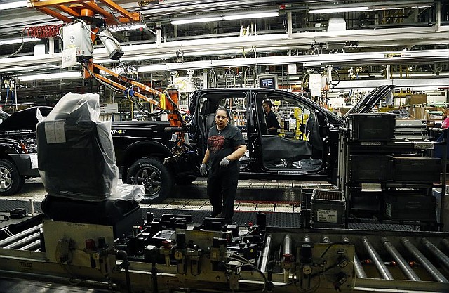An autoworker heads toward a seat for a Titan pickup at Nissan’s Canton, Miss., production line. U.S. factory production slowed in January, the Federal Reserve said. 