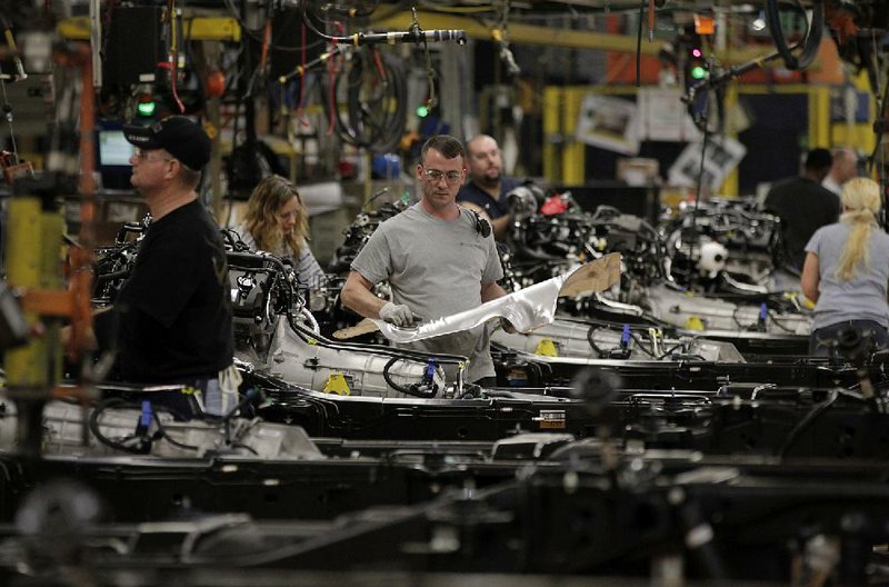 Employees work on the assembly line at the Ford Motor Co. Dearborn Truck Plant in Dearborn, Michigan, U.S., on Thursday, Dec. 13, 2012. Ford's Dearborn Truck Plant, a flagship of the next generation of lean and flexible facilities, is capable of building up to nine different models for three vehicle platforms, while maintaining an environmentally friendly manufacturing processes. Photographer: Jeff Kowalsky/Bloomberg