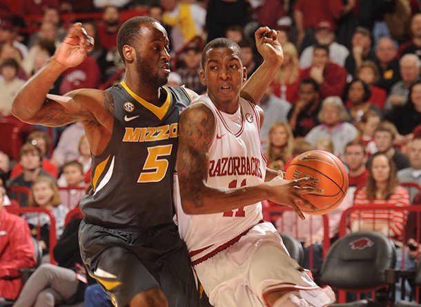 Arkansas sophomore guard BJ Young, right, drives along the baseline as Missouri senior Keion Bell defends Saturday in Bud Walton Arena in Fayetteville. Young scored 18 points, including seven points in the final 29 seconds, as the Razorbacks beat Missouri 73-71.