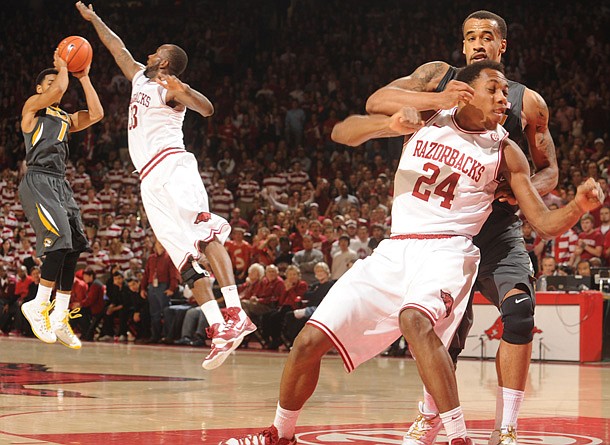 Arkansas freshman Michael Qualls and Missouri senior forward Laurence Bowers get tangled up in the lane as Missouri junior guard Phil Pressey, left, takes a shot over Arkansas junior forward Marshawn Powell Saturday, Feb. 16, 2013, during the second half of play in Bud Walton Arena in Fayetteville. Qualls and Bowers received a double techincal in the game.