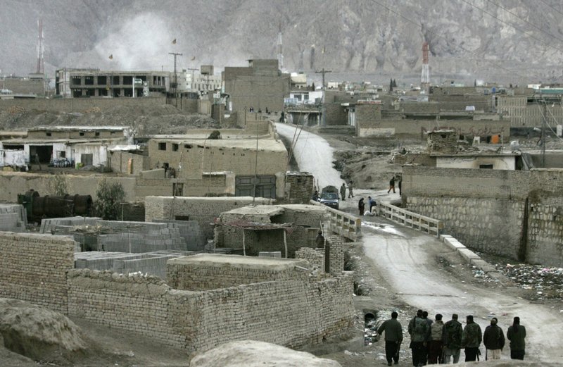 Pakistani security forces take positions in a street leading to the site of a bomb blast, top left, in Quetta, Pakistan, Saturday, Feb. 16, 2013. A bomb ripped through a crowded vegetable market in a mostly Shiite neighborhood in a southern Pakistani city Saturday, killing scores of people in a horrific attack on the country's minority Muslim sect.