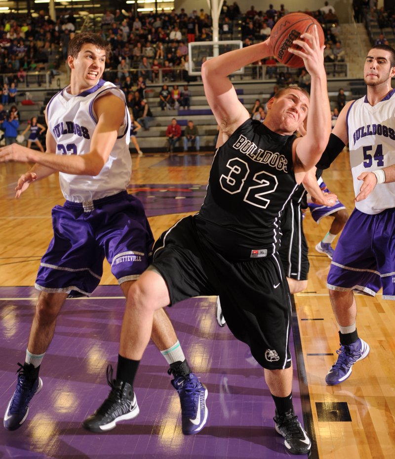 STAFF PHOTO ANDY SHUPE
Springdale junior post Josiah Wymer (32) pulls down a rebound over Fayetteville senior forward Caleb Waitsman, left,  Friday, Feb. 15, 2013, during the first half of play in Bulldog Gymnasium at Fayetteville High School.