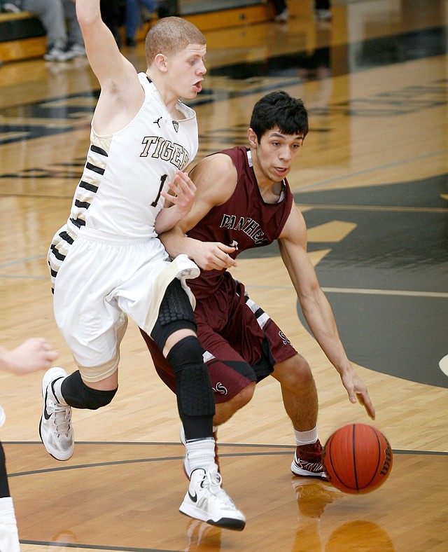 STAFF PHOTO JASON IVESTER
Siloam Springs senior Raul Leyva (right) tries to get around Bentonville freshman Tyrik Dixon during the second half on Friday, Feb. 15, 2013, against Siloam Springs at Bentonville High School.