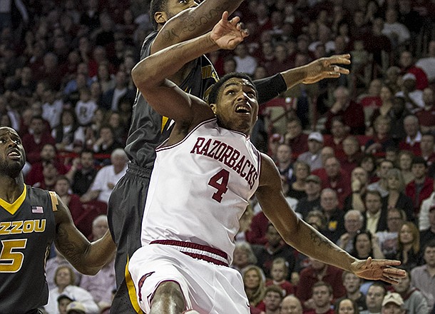 Missouri's Alex Oriakhi, top, attempts to rebound against Arkansas' Coty Clarke (4) during the second half an NCAA college basketball game in Fayetteville, Ark., Saturday Feb. 16, 2013. Arkansas defeated Missouri 73-71. (AP Photo/Gareth Patterson)