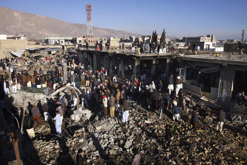 Local residents survey a damaged market caused by Saturday's bombing in Quetta, Pakistan on Sunday, Feb. 17, 2013. The death toll from the horrific bombing that tore through the crowded vegetable market in a mostly Shiite Muslim neighborhood of southwestern Pakistan climbed to 81 with many of the severely wounded dying overnight, a Pakistani police official said Sunday. 