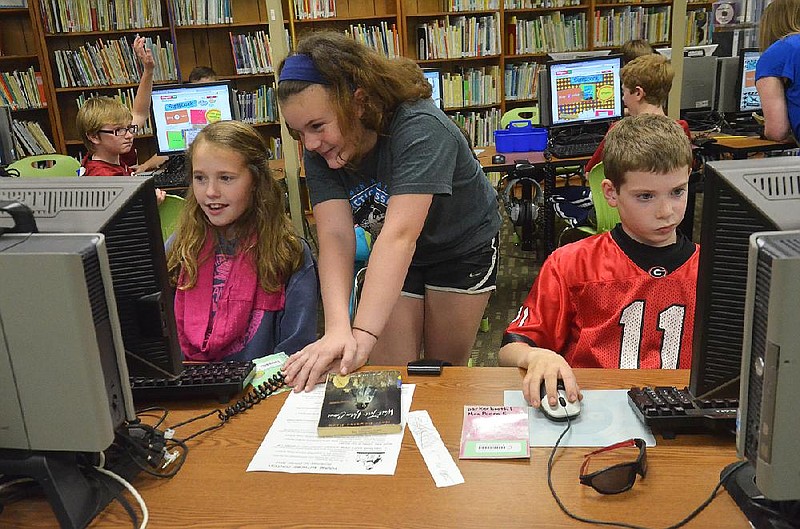 NWA Media/MICHAEL WOODS  --02/07/2013-- Root Elementary 5th graders (left to right) Autumn Blaylock, Abigail Waller and Parker Booth, work on the library computers Thursday afternoon during class.  The students were working on a book genre project. 