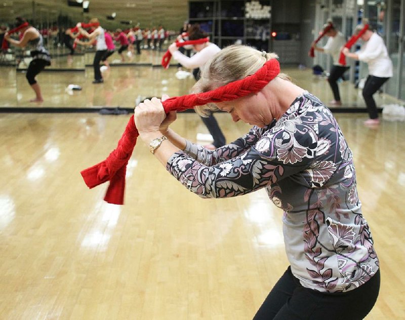 Toni Meghreblian uses a braided towel to stretch her upper back during a session of Fletcher Fusion exercise taught by Julia Taylor at Little Rock Athletic Club on Jan. 31. 