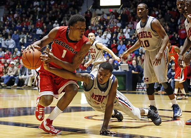 Mississippi guard Jarvis Summers (32) tries to steal the ball from Georgia guard Kentavious Caldwell-Pope (1) in the second half of their NCAA college basketball game in Oxford, Miss., Saturday, Feb. 16, 2013. Mississippi won 84-74. (AP Photo/Rogelio V. Solis)