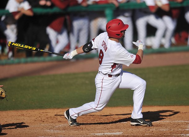 Arkansas batter Tyler Spoon puts the ball into play during his at bat in the sixth inning of the first game in Tuesday afternoon's doubleheader against New Orleans at Baum Stadium in Fayetteville.