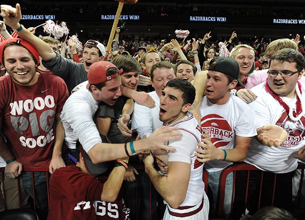 Arkansas junior guard Kikko Haydar celebrates with members of the student section Saturday, Feb. 16, 2013, after beating Missouri at Bud Walton Arena in Fayetteville.