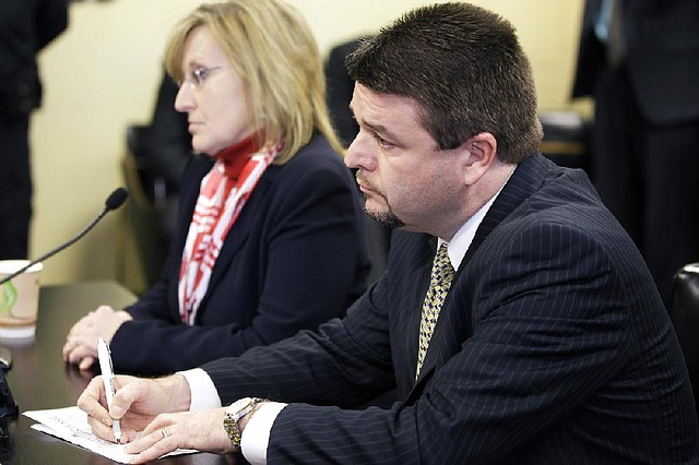 Sen. Jason Rapert, R-Conway, right, keeps track of a roll call vote on his bill dealing with abortion during a meeting of the House Committee on Public Health, Welfare and Labor at the Arkansas state Capitol in Little Rock, Ark., as Rep. Ann V. Clemmer, R-Benton,  listens Tuesday, Feb. 19, 2013. The committee met earlier in the day when a voice vote was taken on the measure but a roll call was requested by the committee's vice chair. (AP Photo/Danny Johnston)