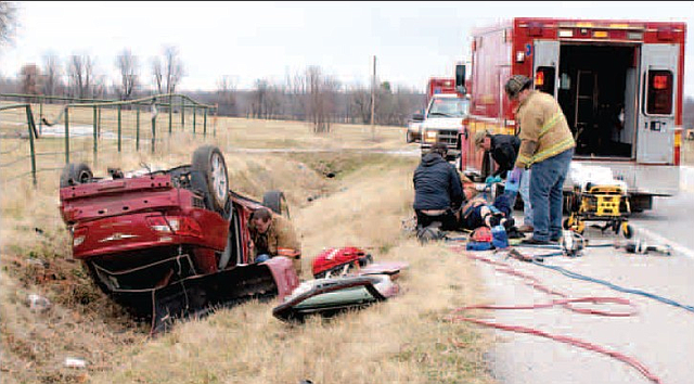 Emergency responders work with one patient injured in a single vehicle rollover accident on Arkansas Highway 72, approximately 4 1/2 miles east of Arkansas 59, on the morning of Feb. 12. Rescuers also work to free a second patient still inside the car. 