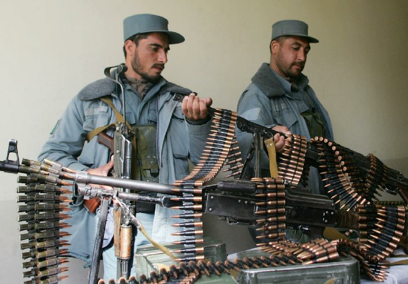 Afghan policemen handle confiscated weapons which are displayed during a ceremony in Herat, west of Kabul, Afghanistan, Wednesday, Feb. 19, 2013. A private security company called Jefa dissolved by Afghan officials of the interior ministry and around 12 weapons confiscated from the center of the dissolved private company, police officials said. (AP Photo/Hoshang Hashimi)