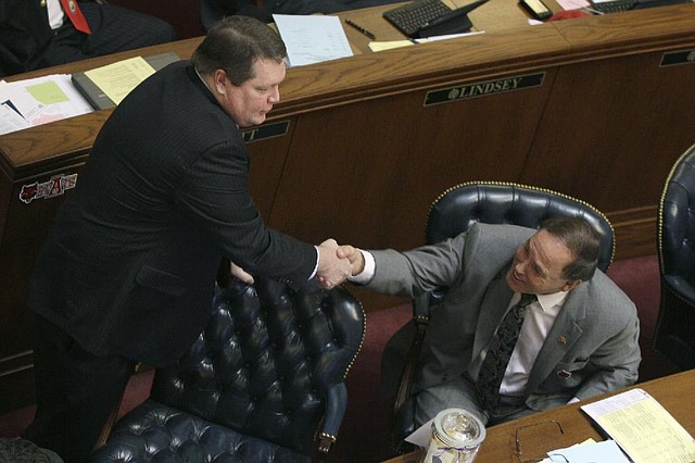 Sen. Bryan King, R-Green Forest, left, is congratulated by Sen. Gary Stubblefield, R-Branch, in the Senate chamber at the Arkansas state Capitol in Little Rock, Ark., after King's bill requiring voters to present a photo identification before they ca cast a ballot Wednesday, Feb. 20, 2013. The bill passed 23-12. (AP Photo/Danny Johnston)