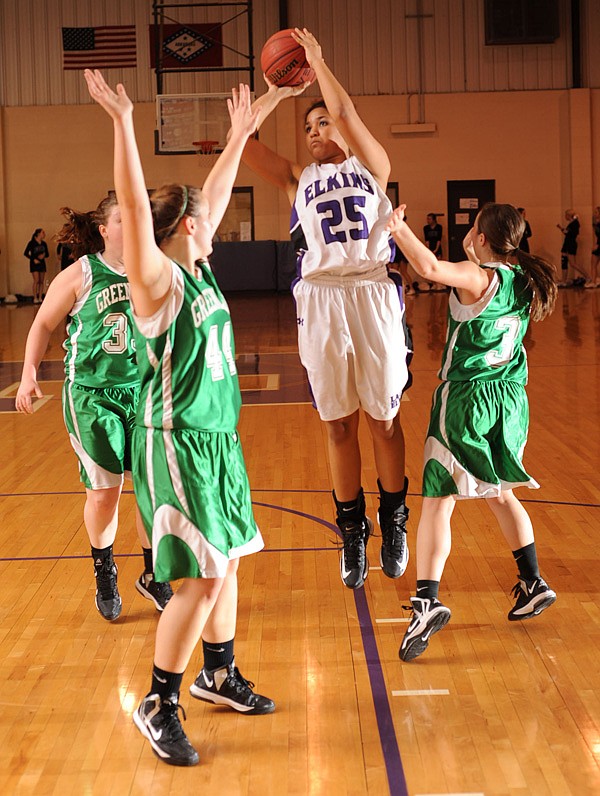 Skyler Johnson, an Elkins junior, takes a shot over Greenland junior Jenny Riggles. left, and senior Morgan Miller during the first half Feb. 1 at Elkins. 