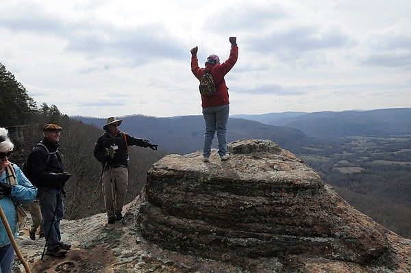 Lou Whisenhunt takes in the view from atop a rock formation during a hike along Home Valley Bluff on Friday. The hike followed the lip of the bluff for views of the valley below and surrounding hill country. 