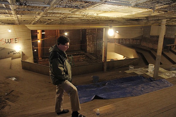 John Mack, building owner, checks out the flooring in the balcony of the former opera house in Rogers. There were no chairs in the balcony, visitors sat on the built-in risers. 