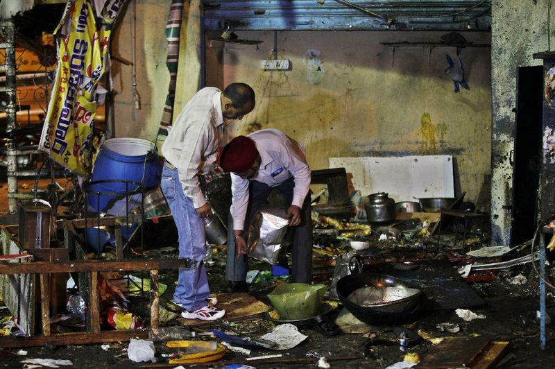 Investigators collect evidence today from the debris at one of two sites where bombs went off Thursday in Hyderabad, India. 