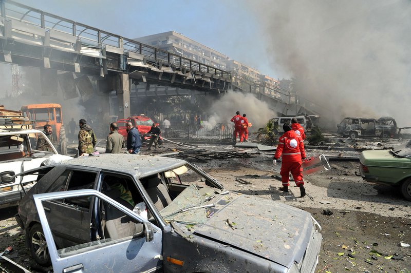 This photo released by the Syrian official news agency SANA, shows first responders working after a huge explosion that shook central Damascus, Syria, on Thursday, Feb. 21, 2013. 