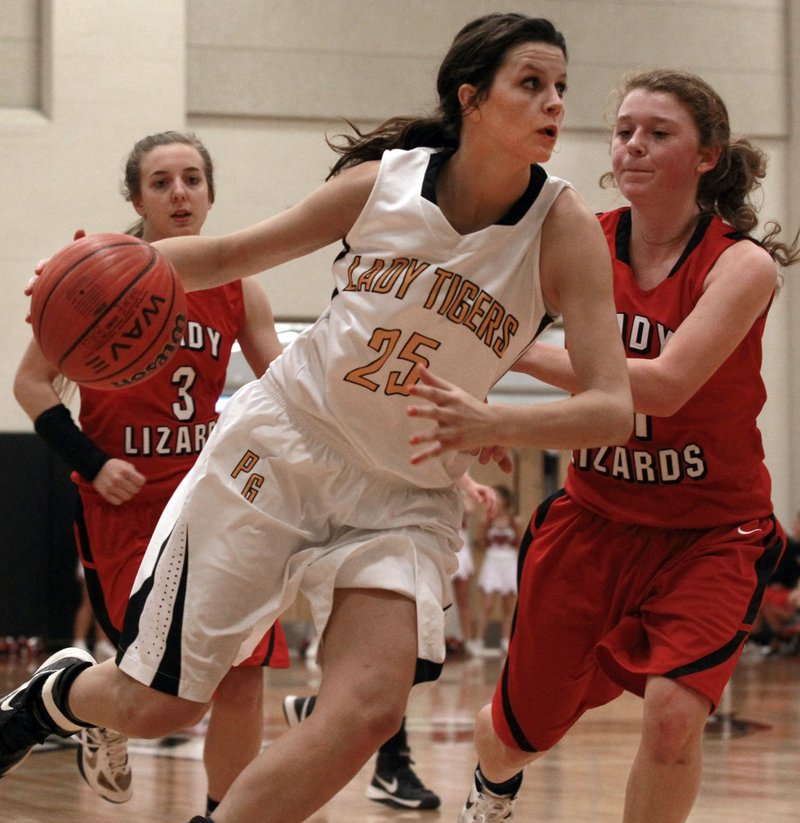 Prairie Grove’s Justyne Huber (25) drives around Dardanelle defender Shelbie Shay during Thursday’s 4A North regional game at Maumelle High School. Huber finished with 20 points to lead the Lady Tigers. 