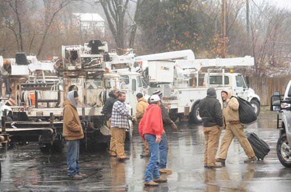 Utility crews from Texas and Kansas gather Thursday around their trucks outside the Days Inn in Fayetteville after spending the night in town in anticipation of utility service damage from an expected ice storm. 