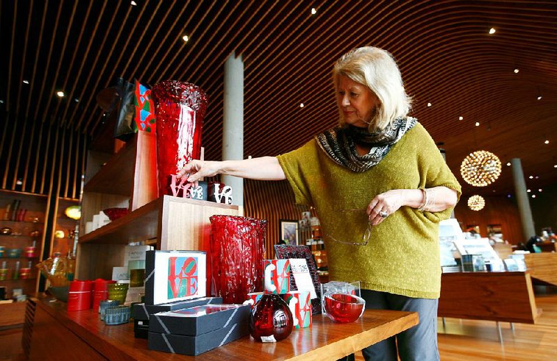 Mary Douthit, retail operations manager, organizes a display on Wednesday, Feb. 6, 2013, inside the museum store at Crystal Bridges Museum of American Art in Bentonville.