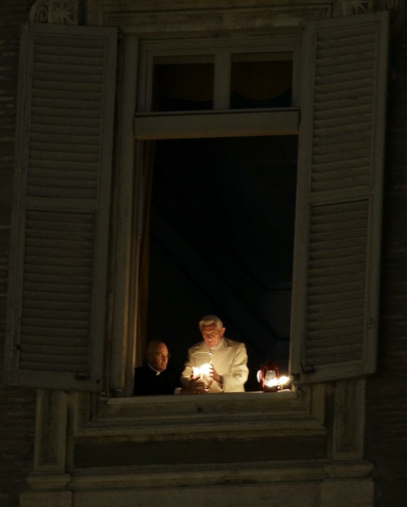 Pope Benedict XVI, seen here lighting a candle at his window overlooking St. Peter’s Square, is leaving the papacy on Thursday. 