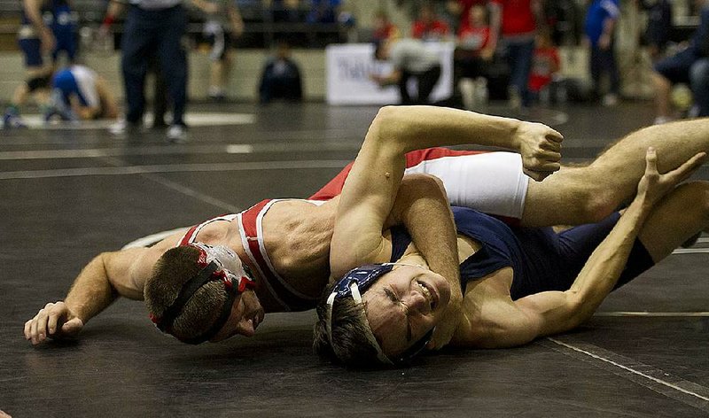 Kyle Wheeler of Cabot (left) tries to pin Greenwood’s Trenton Cowan in a 152-pound match Friday at the Jack Stephens Center in Little Rock. Wheeler pinned Cowan at 3:26 of the second period. 