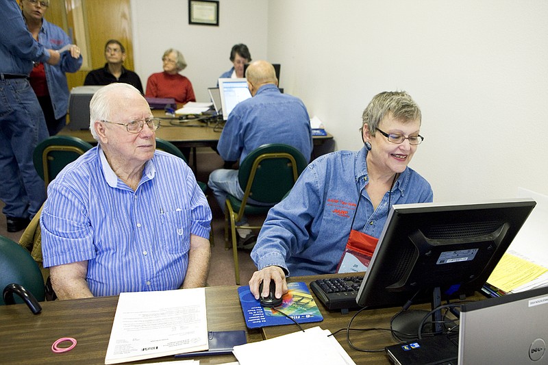 Jill Williams, right, an AARP Foundation Tax-Aide volunteer, helps Lloyd Myer with filing his taxes at the McAuley Center outside of Hot Springs Village.