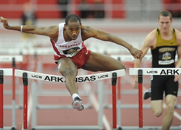 Arkansas senior Caleb Cross clears the final hurdle on his way to a second-place finish ahead of Missouri junior Andy Schuckenbrock in a preliminary heat of the 60-meter hurdles Saturday, Feb. 23, 2013, during the Southeastern Conference Indoor Track and Field Championships at the Randal Tyson Track Center in Fayetteville.