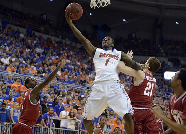 Florida guard Kenny Boynton (1) goes to the basket as Arkansas guard Mardracus Wade (1) and forward Hunter Mickelson (21) defend during the first half of an NCAA college basketball game in Gainesville, Fla., Saturday, Feb. 23, 2013. (AP Photo/Phil Sandlin)