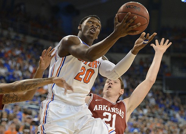 Florida's Erik Murphy (33) tries to block Arkansas guard Michael Qualls (24) as he struggles under the basket during the first half of an NCAA college basketball game in Gainesville, Fla., Saturday, Feb. 23, 2013. (AP Photo/Phil Sandlin)