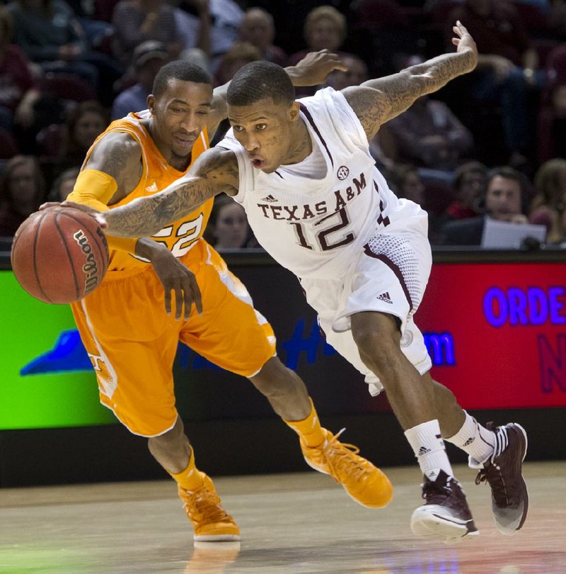 Texas A&M guard Fabyon Harris (12) drives past Tennessee guard Jordan McRae during the first half of Saturday’s game in College Station, Texas. Tennessee won 93-85 in four overtimes. 