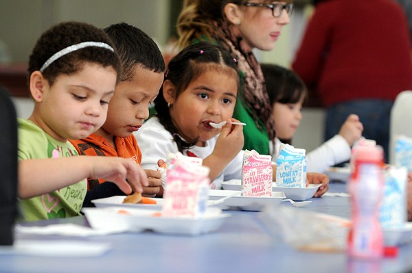 Makenzi Hoskins, 4, from left, Andy Barbosa-Rodriguez, 5, and Nicole Marcia-Martinez, 4, all prekindergarten students, eat their lunches Wednesday at the Springdale School District’s Early Childhood Center. 