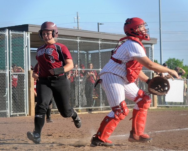 Madison Moore, Springdale High shortstop, crosses home plate as Farmington’s Kendra Center waits for the ball to be thrown in April 6 at J.B. Hunt Park in Springdale. 