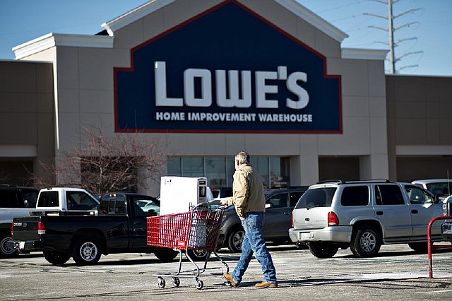 A customer pushes a shopping cart outside a Lowe’s store in East Peoria, Ill., on Wednesday. Lowe’s reported a fourth-quarter profi t Monday that beat analysts’ estimates. 