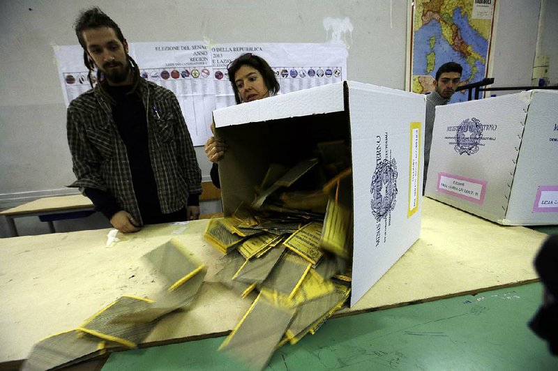 Boxes are emptied for ballots to be counted at a polling station in Rome, Monday. 