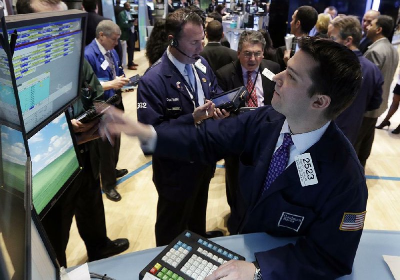 Specialist Robert Canzani (right) works at his post Monday on the floor of the New York Stock Exchange. 