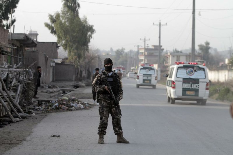 A security official stands guard at the scene of a suicide car-bomb attack that killed and injured several people at the National Directorate of Security in Jalalabad, Afghanistan, on Sunday. 