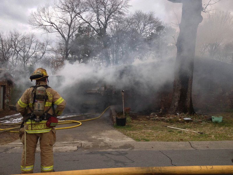 Little Rock firefighters battle a house fire at 36th and High streets late Tuesday morning.