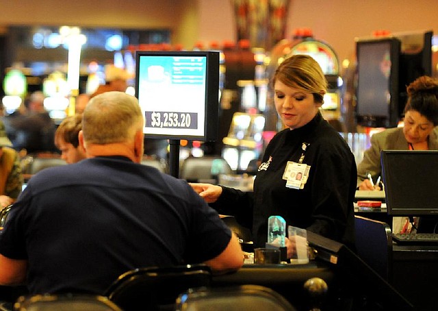
Holley Garrett, dealer at Cherokee Casino and Hotel, at the three card poker table Monday, Feb. 25, 2013 at the casino in West Siloam Springs, Okla. The casino has a number of machines, tables, poker room and off track betting room.