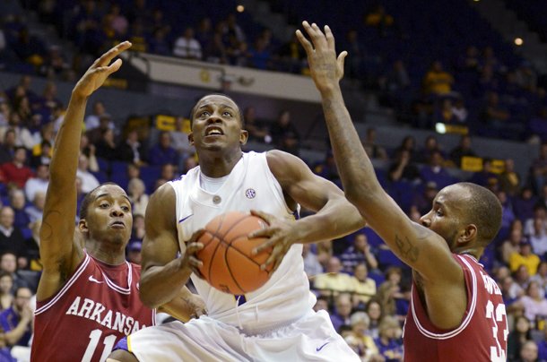 LSU's Anthony Hickey (1) splits Arkansas defenders B.J. Young (11) and Marshawn Powell (33) for a shot during an NCAA basketball game, Wednesday, Feb. 27, 2013, in Baton Rouge, La. LSU won 65-60. (AP Photo/The Advocate, Heather McClelland)