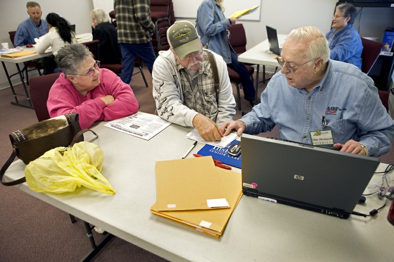 Olan Thompson, right, helps Glen and Gladys Tucker prepare their taxes at Faith Missionary Baptist Church in Cabot. The Tuckers are taking advantage of the AARP Tax-Aide program, which provides free tax assistance.