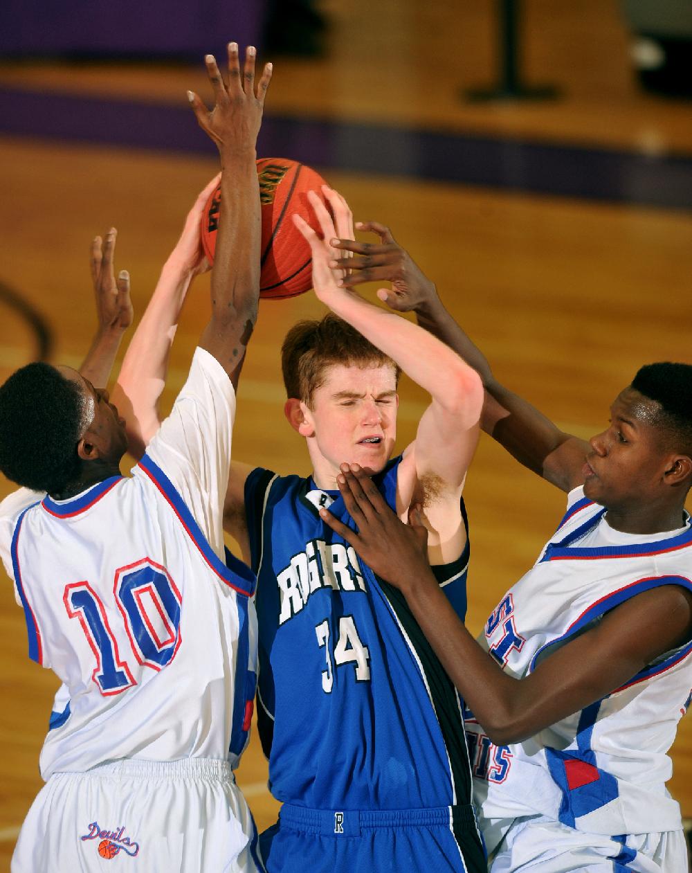 NWA Media/MICHAEL WOODS --02/22/2013-- West Memphis defenders Rai East (left) and Keari Brown put the pressure on Rogers forward Jake Killingsworth as he tries to get the ball up the court in the second half of their game in the boys 7A state basketball tournament in at Fayetteville high School. Rogers lost to West Memphis in overtime.