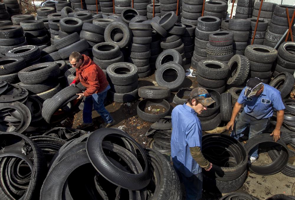 Arkansas Democrat-Gazette/BENJAMIN KRAIN --2/28/2013--
Workers with Parker Tire & Auto on Harkrider St. in Conway, from left, Clint Maxwell, Cory Grable and Jose Trujillo disassemble tire sidewalls from treads on scrap tires to reduce mosquito breeding and ensure they are propery recycled according to state law. The Arkansas Waste Tire Program law also requires dealers to pay $2 to the state per new tire sold to fund tire recycling and desposal operations.